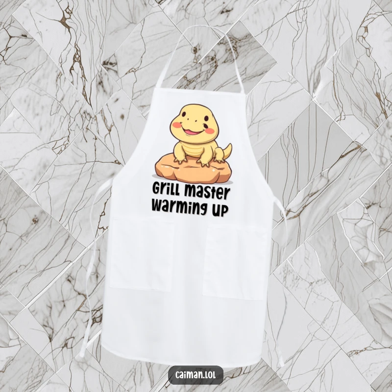 Funny apron displaying a round, friendly reptile with a big smile, sunning happily, ready to help you cook up a storm in the kitchen.