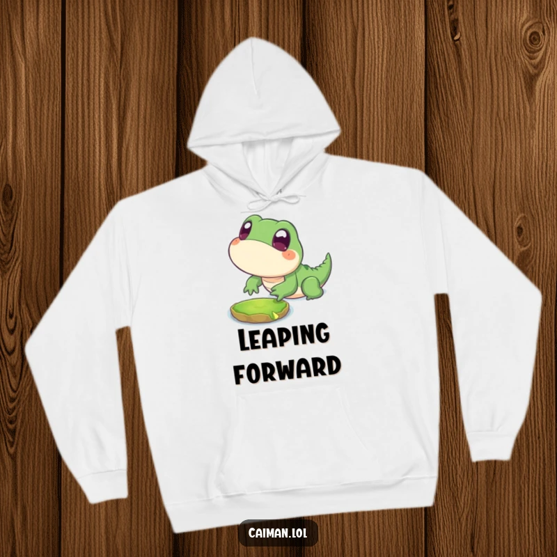Funny Hoodie featuring a chubby, stylized reptile with big, innocent eyes playfully lunging towards a floating lily pad, perfect for cozy adventures.